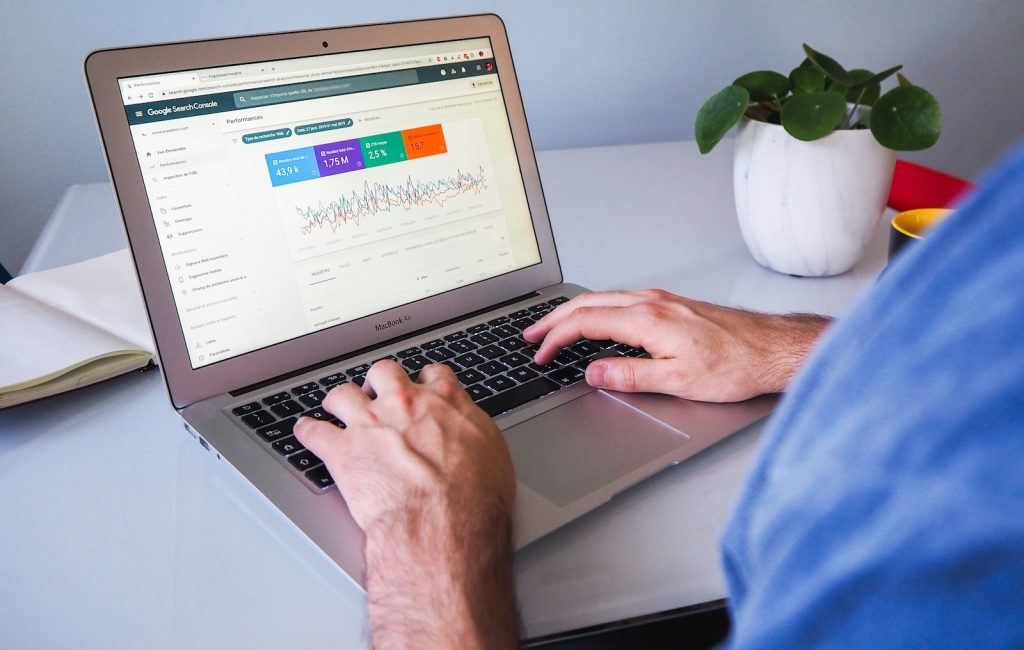 Google search console traffic graph on a laptop with an SEO expert typing